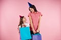 Young mother and daughter in party caps