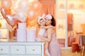 A young mother and daughter in pink pajamas are hugging in the dressing room