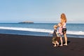 Young mother, daughter, son run by black sand beach Royalty Free Stock Photo