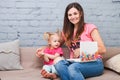 Young mother and daughter of two years old blonde use laptop computer laptop white with bright print sitting on couch indoors Royalty Free Stock Photo