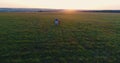 Young mother with daughter walk and run by hands in the field at sunset. Aerial view.