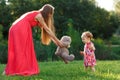 Young mother in dress takes bear little daughter in park Royalty Free Stock Photo