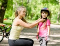 Young mother dresses her daughter's bicycle helmet Royalty Free Stock Photo