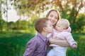 Young mother, eldest son and little daughter. Brother kissing baby sister. Happy family concept