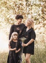 Young mother embraces two daughters on nature in summer. Girls hug together, laugh, have fun. Traveling with children, maternal