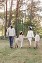 Young mother, father with daughter and sons are walking, having fun in autumn forest. Family holding hands enjoying time Royalty Free Stock Photo