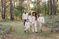 Young mother, father with daughter and sons are walking, having fun in autumn forest. Family holding hands enjoying time Royalty Free Stock Photo