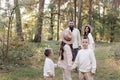 Young mother, father with daughter and sons are walking, having fun in autumn forest. Family holding hands enjoying time Royalty Free Stock Photo