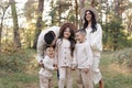 Young mother, father with daughter and sons are walking, having fun in autumn forest. Family holding hands enjoying time Royalty Free Stock Photo