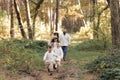 Young mother, father with daughter and sons are walking, having fun in autumn forest. Family holding hands enjoying time Royalty Free Stock Photo