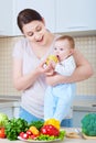 Young mother feeding baby apple. A happy family.