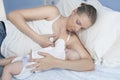 Young mother feeding breast her baby laying in her bedroom Royalty Free Stock Photo