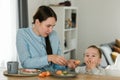 Young mother feeding her baby son with fruit Royalty Free Stock Photo