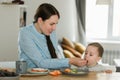Young mother feeding her baby son with fruit Royalty Free Stock Photo