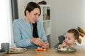 Young mother feeding her baby son with fruit Royalty Free Stock Photo