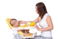 Mother feeding her baby son with fruit puree