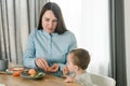 Young mother feeding her baby son with fruit Royalty Free Stock Photo