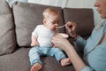 Young mother feeds her daughter with a spoon of fruit puree