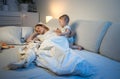 Young mother fell asleep next to her baby boy in bed Royalty Free Stock Photo