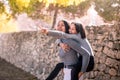 Young mother giving piggyback to her daughter. Pretty little girl surprised and excited pointing something to her mother Royalty Free Stock Photo