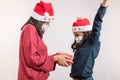 Young mother giving a present to her daughter on white background. Christmas with face mask during coronavirus epidemic Royalty Free Stock Photo