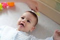 Young mother hand holding comb and brushing her baby. Close up Mother care. Concept of parenthood Royalty Free Stock Photo