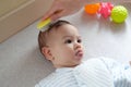 Young mother hand holding comb and brushing her baby. Close up Mother care. Concept of parenthood Royalty Free Stock Photo