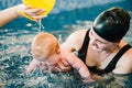 Young mother, happy little girl in the pool. Teaches infant child to swim. Enjoy the first day of swimming in water. Royalty Free Stock Photo