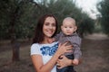 The young mother held a little son in her arms. Family walk in autumn in the garden Royalty Free Stock Photo