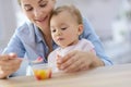 Young mother helping eating to her baby Royalty Free Stock Photo