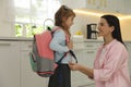 Young mother helping her little child get ready for school in kitchen Royalty Free Stock Photo