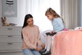 Young mother helping her little child get ready for school in bedroom Royalty Free Stock Photo