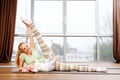 Young mother and her babie doing yoga exercises on rugs at fitness studio. Royalty Free Stock Photo