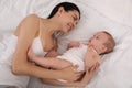 Young mother with her baby on bed, above view Royalty Free Stock Photo