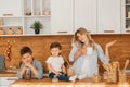 Young mother with her baby daughter in a modern kitchen setting. Young attractive cook woman desperate in stress, tired Royalty Free Stock Photo