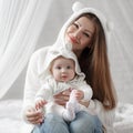 Young mother and her baby daughter playing togerher on the bed at home Royalty Free Stock Photo