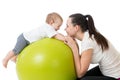 Young mother and her baby doing yoga exercises on gymnastic ball isolated over white Royalty Free Stock Photo