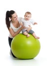 Young mother and her baby infant doing yoga exercises on gymnastic ball isolated over white Royalty Free Stock Photo