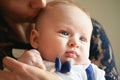 Young mother with her baby son, detail on heads close together, as she`s kissing him on head Royalty Free Stock Photo