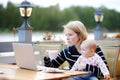 Young mother with her baby working or studying on laptop Royalty Free Stock Photo