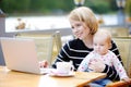 Young mother with her baby working or studying on laptop Royalty Free Stock Photo