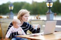 Young mother with her baby working or studying on laptop Royalty Free Stock Photo