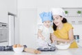 Young mother and her child making cake