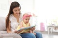 Young mother with her cute baby girl reading book Royalty Free Stock Photo