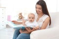 Young mother with her cute baby girl reading book Royalty Free Stock Photo