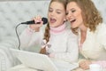 Portrait of a mother and daughter singing karaoke