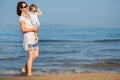 Young mother and her cute little baby girl playing on a beautiful tropical beach Royalty Free Stock Photo