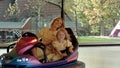 Young mother with her daughter drive on bumper cars Royalty Free Stock Photo