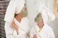 Young mother and her daughter with masks having fun in bathroom Royalty Free Stock Photo