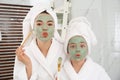 Young mother and her daughter with masks having fun in bathroom Royalty Free Stock Photo